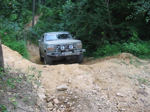 1988 Ford Bronco - This Ford Bronco navigates a challenging off-road trail with steep inclines and loose gravel.