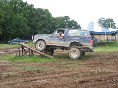 1988 Ford Bronco - Muddy field obstacle course with a 1988 Ford Bronco and another truck.