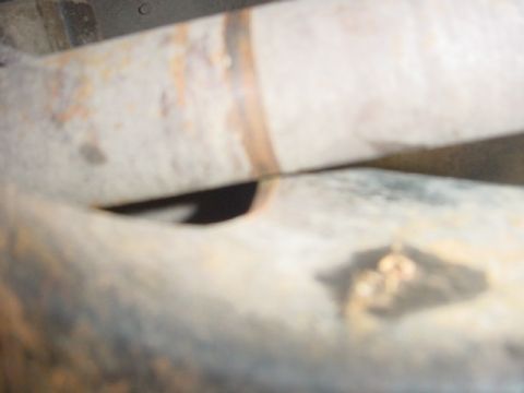 1988 Ford Bronco - Close-up view of rusted metal pipes, likely from a vehicle's exhaust or frame.