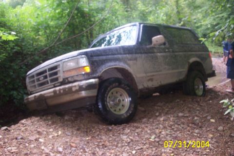 1979 Ford F-150 - Mud-covered SUV navigating a challenging off-road path with a date stamp of July 31, 2004.