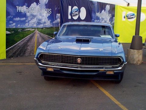 1999 Ford Taurus - A blue 1970 Ford Torino is displayed in front of a Ford 100th anniversary banner.