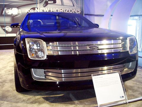 1999 Ford Taurus - A Ford concept car is displayed indoors with informational text beside it.