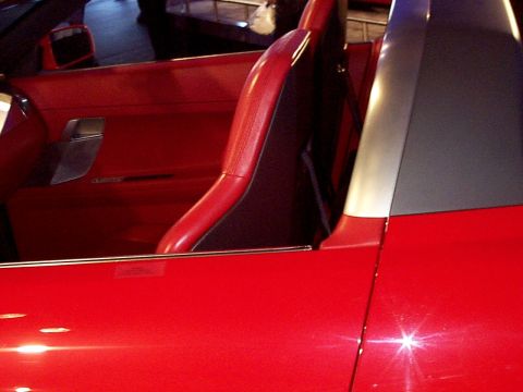 1999 Ford Taurus - Close-up of a red sports car's interior, showing the driver's seat and door panel.