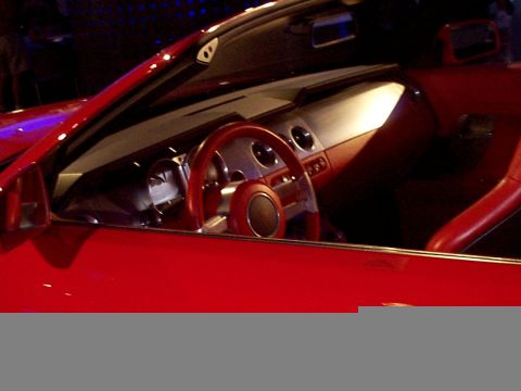 1999 Ford Taurus - Interior view of a red convertible, highlighting the steering wheel and dashboard details.