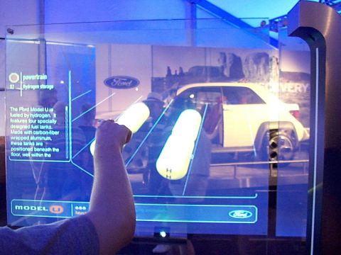 1999 Ford Taurus - Interactive display shows a white Ford Model U concept car, highlighting its hydrogen storage and powertrain details.