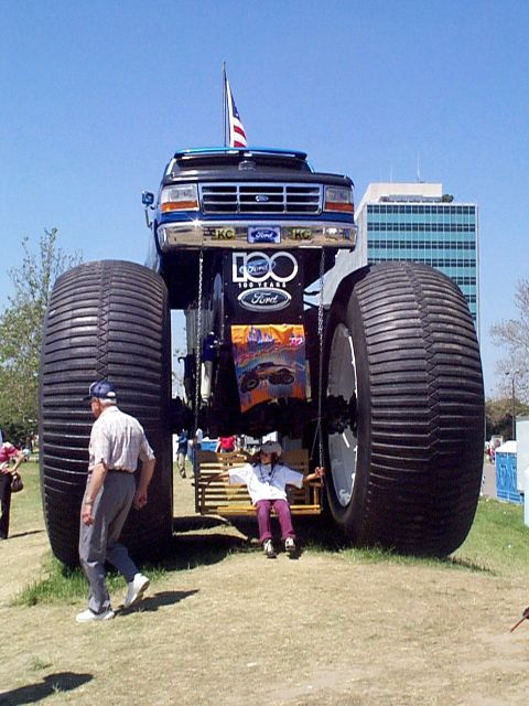 1999 Ford Taurus - A modified Ford truck with massive tires and a 100th anniversary badge is displayed outdoors.