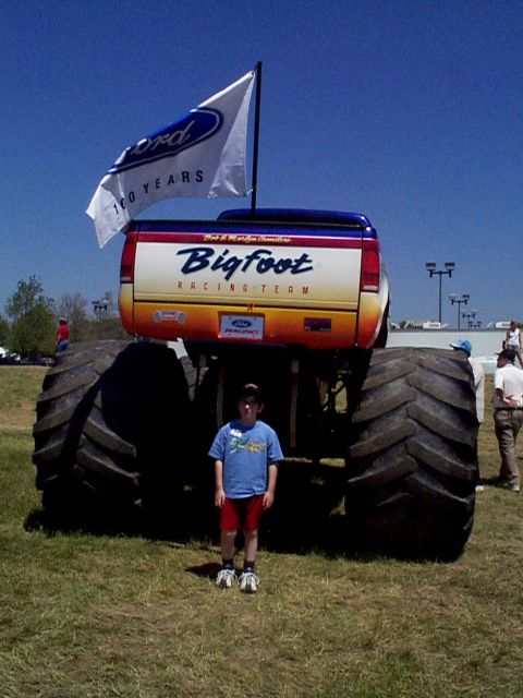 1999 Ford Taurus - A child poses with a Bigfoot monster truck flying a Ford 100th anniversary flag.