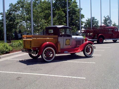 1999 Ford Taurus - Two vintage vehicles, a pickup and a fire truck, are parked in a lot on a sunny day.