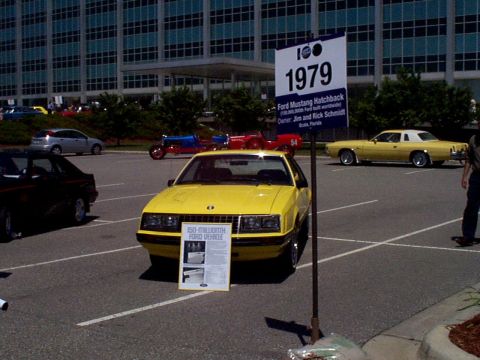 1999 Ford Taurus - A yellow 1979 Ford Mustang Hatchback is displayed with a sign detailing its significance as the 150-millionth Ford vehicle produced.