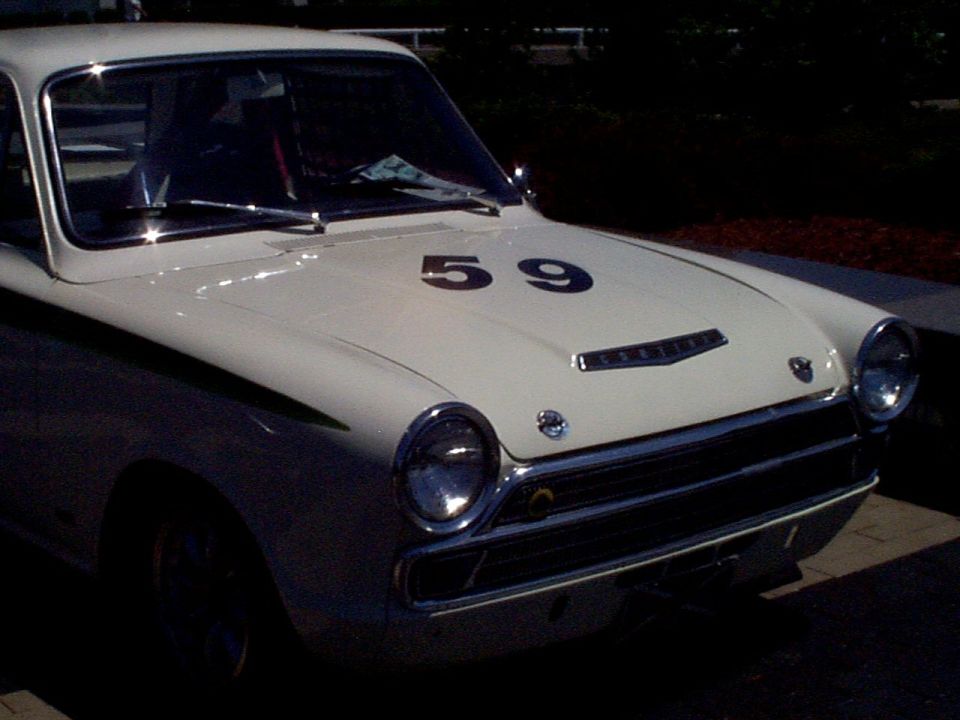 Front view of a white race car with black stripes and the number 59 on the hood