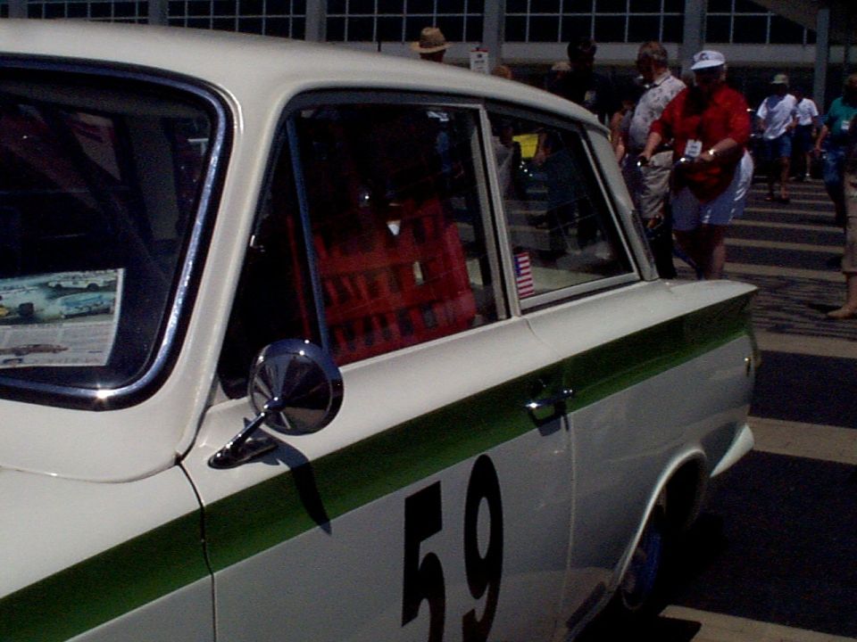 White sedan with green stripe and number 59, side view, chrome mirror, red interior visible