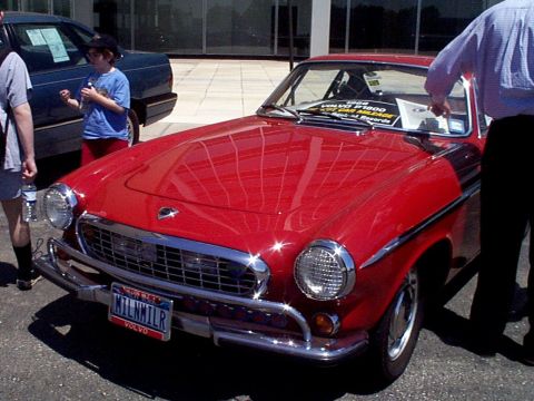 1999 Ford Taurus - Front view of a classic red Volvo P1800 coupe at an outdoor event.