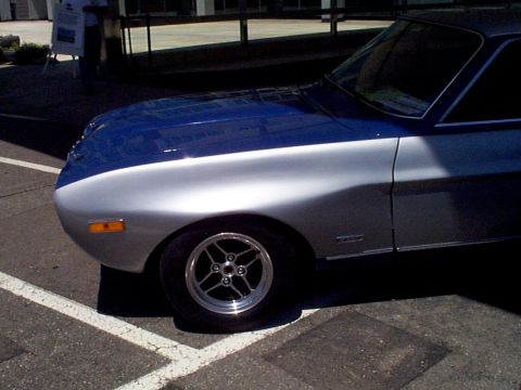 1999 Ford Taurus - A two-tone blue and silver coupe is seen from the front quarter angle, showing its distinctive fender and hood design.