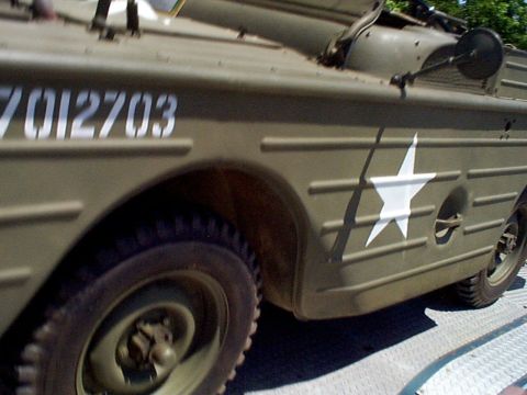 1999 Ford Taurus - Side view of a military amphibious vehicle, possibly a DUKW, with US star insignia.