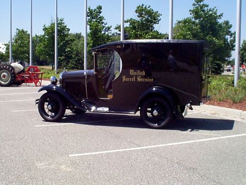 1999 Ford Taurus - This vintage delivery truck, marked 'United Parcel Service', is parked in a lot next to a tractor.