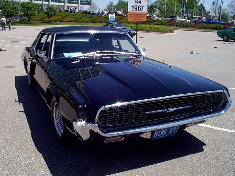 1999 Ford Taurus - A dark-colored classic car, identified as a 1967 Ford Thunderbird, is parked outdoors.