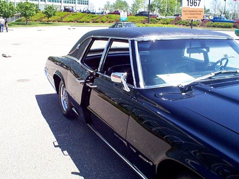 1999 Ford Taurus - A black coupe is parked outdoors, with a sign indicating it is a 1967 Ford Thunderbird.