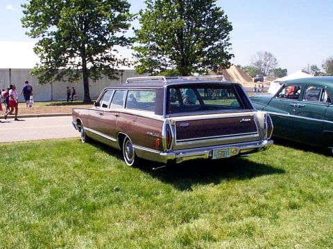 1999 Ford Taurus - Station wagon with wood paneling and roof rack parked on grass next to another car.