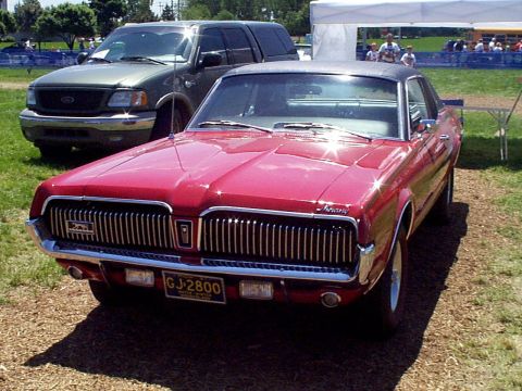 1999 Ford Taurus - Front view of a red 1969 Mercury Cougar XR7 with a large chrome grille.