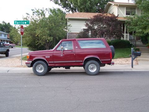 1991 Ford Bronco - This Ford Bronco is parked on a residential street next to a mailbox and a stop sign.