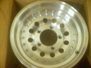 1989 Ford Bronco - Close-up of an aluminum wheel, likely a replacement part, with visible text from SuperMotors.net.