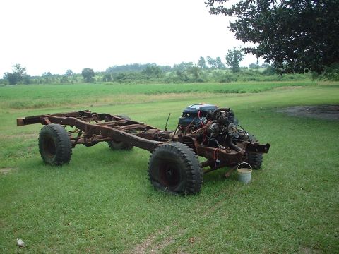 1976 Ford F-150 - This is a bare truck chassis with an engine, parked outdoors on a grassy field.
