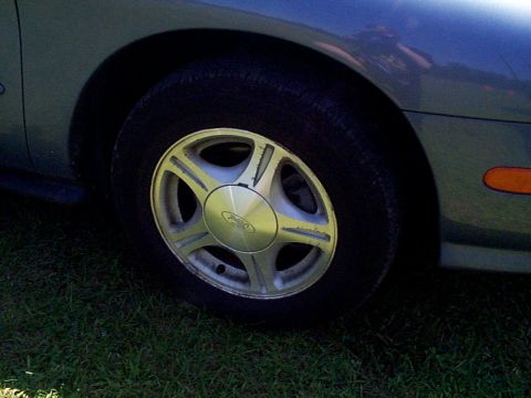 1999 Ford Taurus - Close-up of a 1999 Ford Taurus SE alloy wheel, showing the Ford logo on the center cap.