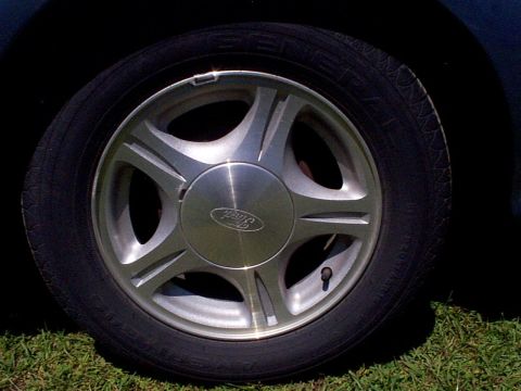 1999 Ford Taurus - The wheel on this 1999 Ford Taurus SE features the iconic Ford emblem on its hubcap.