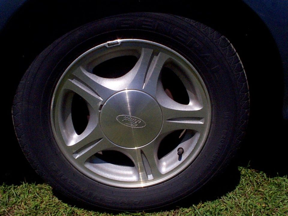 Close-up of a 1999 Ford Taurus SE wheel with a Ford logo on the hubcap