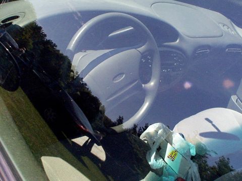 1999 Ford Taurus - Interior view of a 1999 Ford Taurus, showing the steering wheel, dashboard, and passenger airbag.