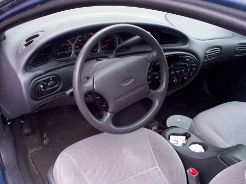 1999 Ford Taurus - Interior view of a 1999 Ford Taurus, highlighting the dashboard and seating area.