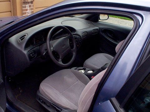 1999 Ford Taurus - Interior view of a blue 1999 Ford Taurus, highlighting the driver's seat and dashboard.