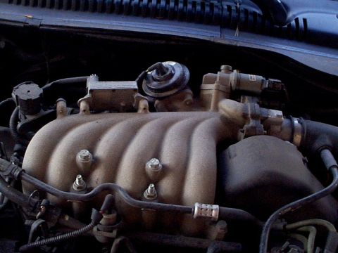 1999 Ford Taurus - Close-up view of an engine's intake manifold, showing various components and connections.