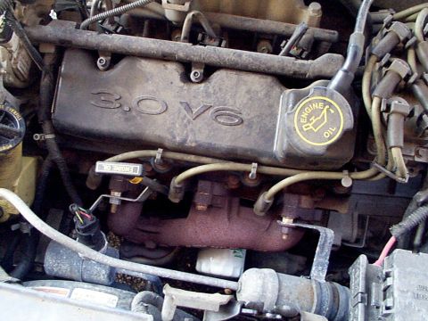 1999 Ford Taurus - Close-up of a Ford 3.0L V6 engine, showing the valve cover and oil cap.