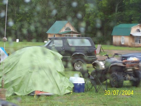 1995 Ford Bronco - A 1995 Ford Bronco is parked at a campsite with a tent and ATV visible.