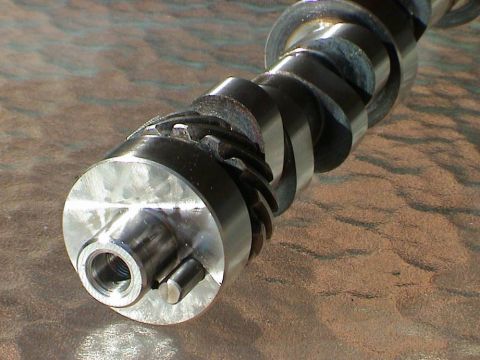 1979 Ford Bronco - Close-up of a camshaft, a critical engine component, showing its detailed machining and threaded end.