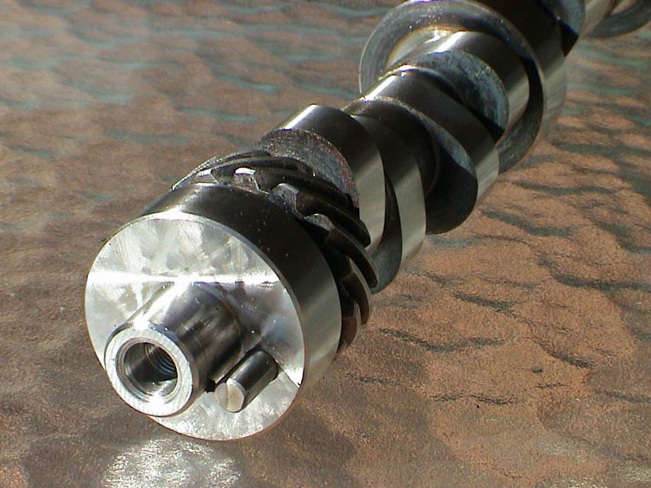 Close-up of camshaft snout showing threaded bolt hole, dowel pin, gear and lobes