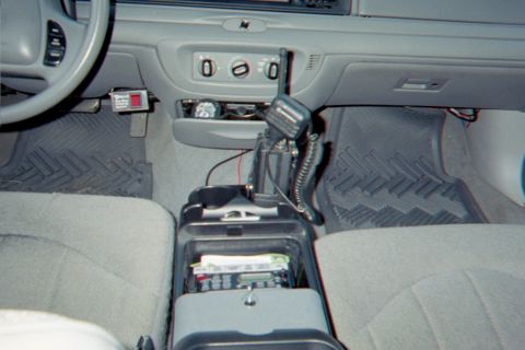 1998 Ford Crown Victoria - The center console of a vehicle is equipped with radio communication devices and a CB antenna.