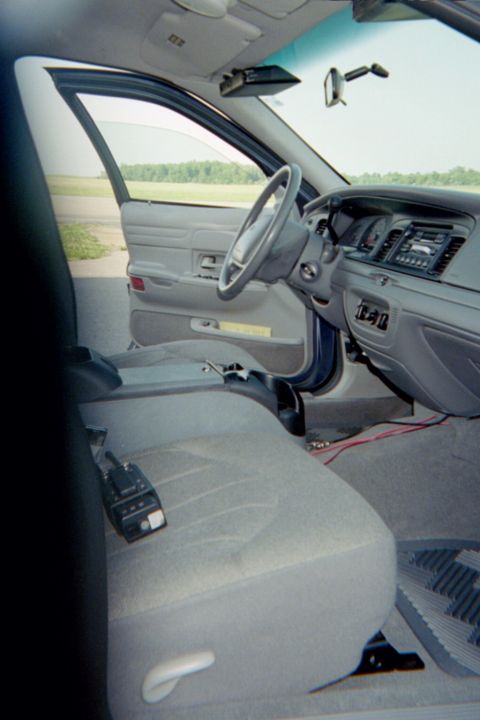 1998 Ford Crown Victoria - The interior of a 1998 Ford Crown Victoria is visible, the dashboard, steering wheel, and front seats.