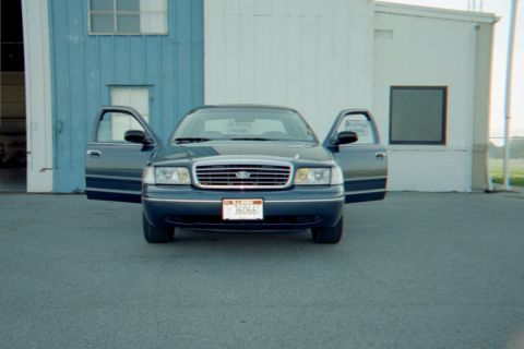 1998 Ford Crown Victoria - Front view of a 1998 Ford Crown Victoria with all doors open, parked in front of a building.
