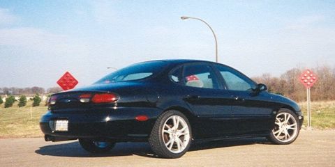 1999 Ford Taurus - Rear 3/4 view of a black 1999 Ford Taurus sedan parked outdoors.