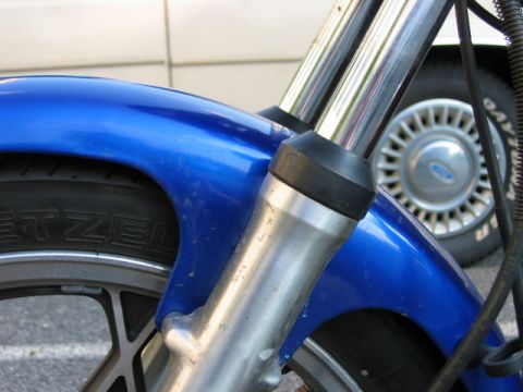 1985 Ford Crown Victoria LTD - Close-up of a blue motorcycle's front fender and suspension components.