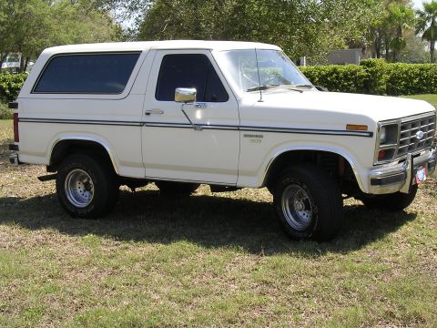 1985 Ford Bronco - This 1985 Ford Bronco features a white exterior and is viewed from a three-quarter front angle.