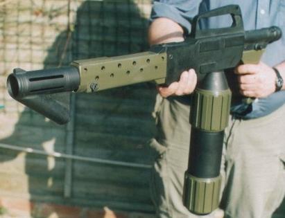 1988 Ford Bronco - A person holds a prop gun with a distinctive barrel and magazine.
