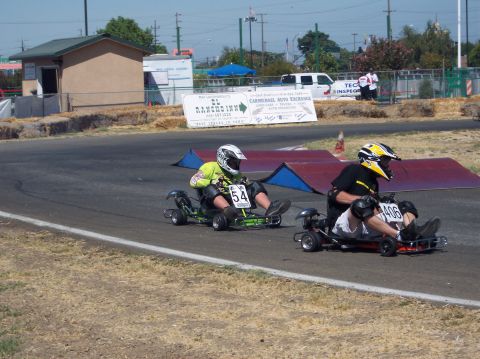 1990 Ford Bronco - Go-karts compete on a sunny day at a race track.