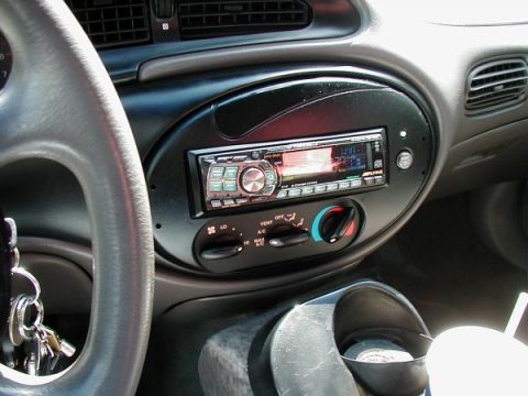 1997 Ford Taurus - The interior of a vehicle shows the dashboard, steering wheel, and an aftermarket stereo system.