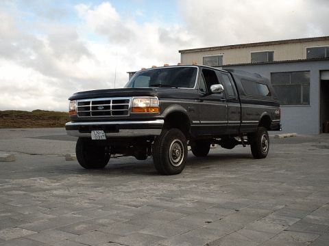 1996 Ford Bronco - This Ford F-250 pickup truck, likely from the early to mid-1990s, is shown with a dark gray finish and a matching camper shell.