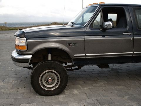 1996 Ford Bronco - Ford F-250 truck seen from the side, parked outdoors with the ocean in the background.