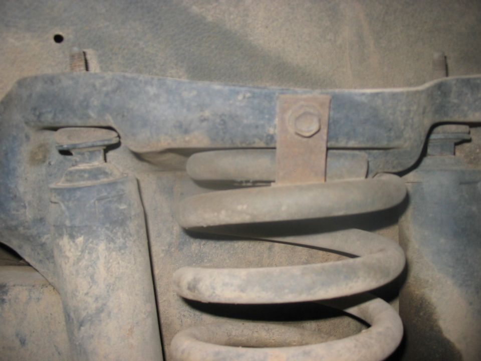 Close-up of a vehicle's coil spring and mounting bracket
