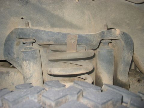 1988 Ford Bronco - This photo shows the front suspension spring and tire of a vehicle, with a watermark for Supermotors.net.